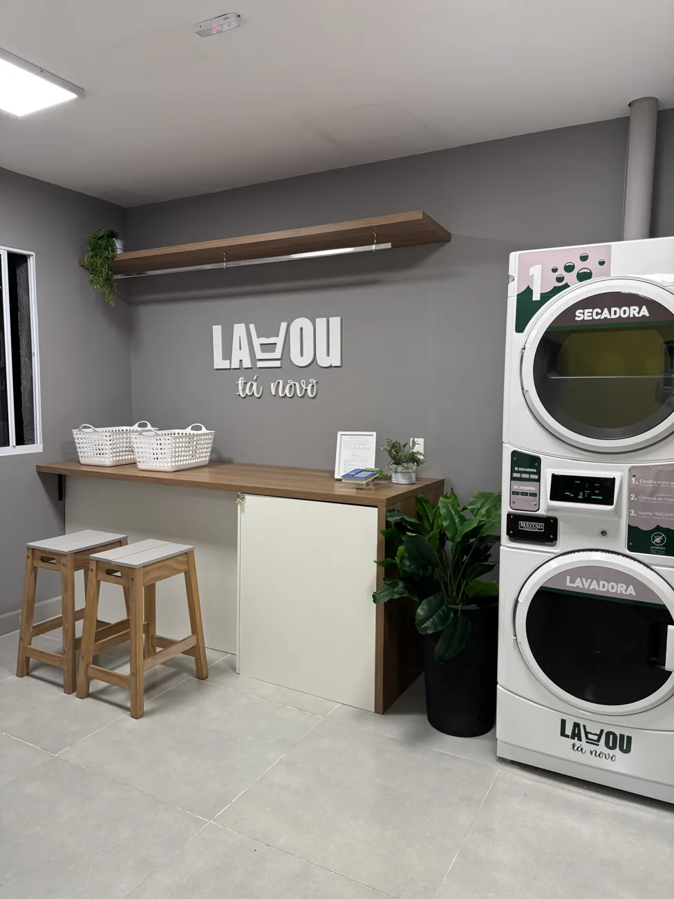 Lavanderia da unidade Mooca com bancada de madeira, bancos e máquinas empilhadas